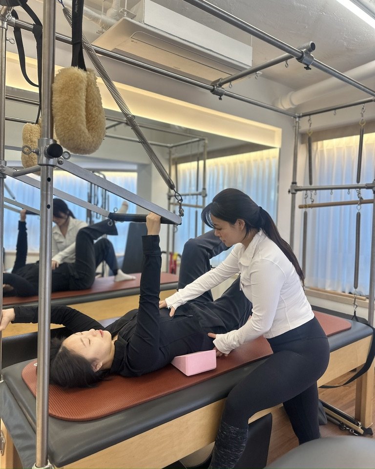 물리치료사 출신 강사가 기구 위에서 회원의 자세를 지도하는 모습